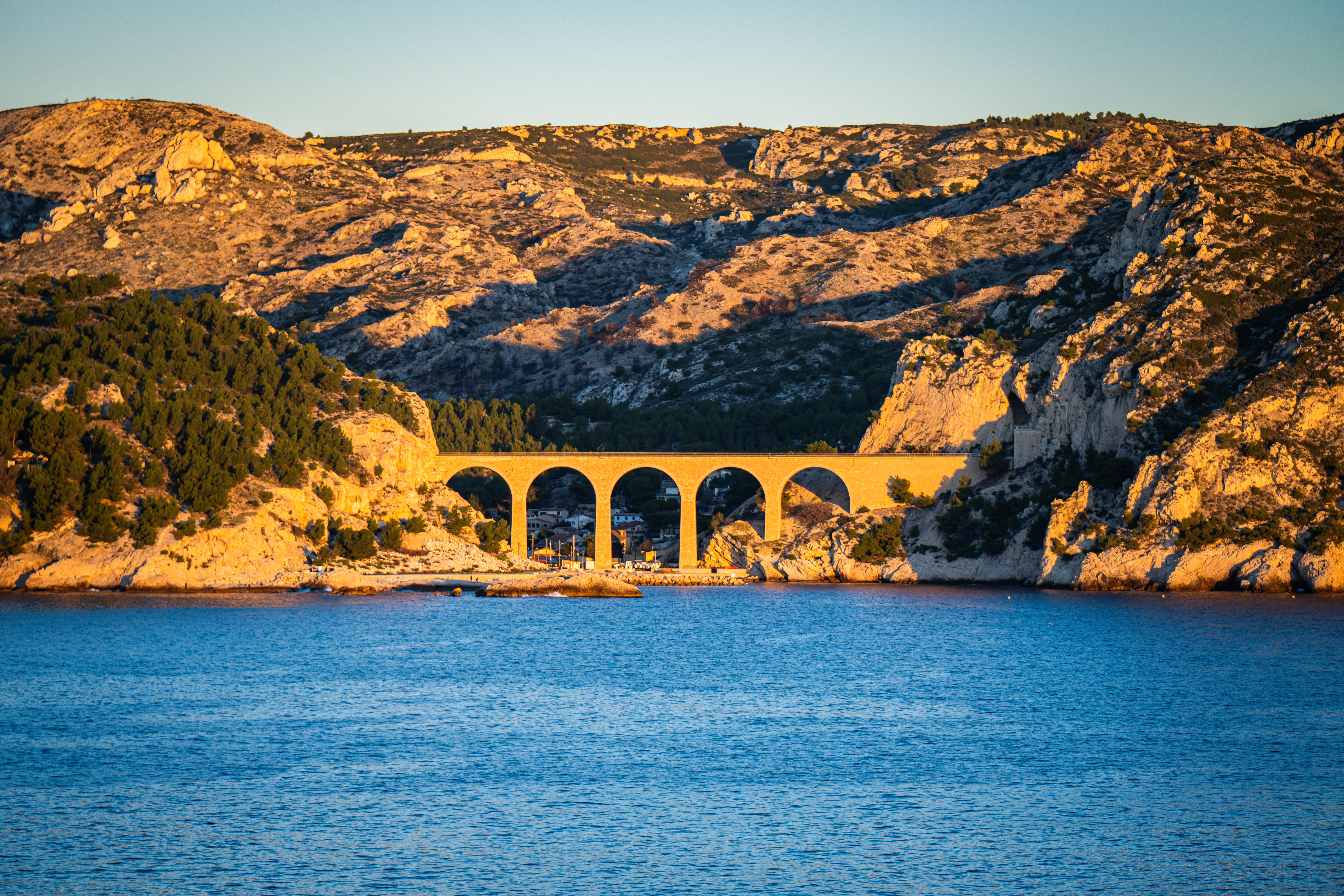 Vue imprenable sur le pont en arc de Marseille, en Provence, avec les teintes dorées du coucher de soleil sur la mer Méditerranée.