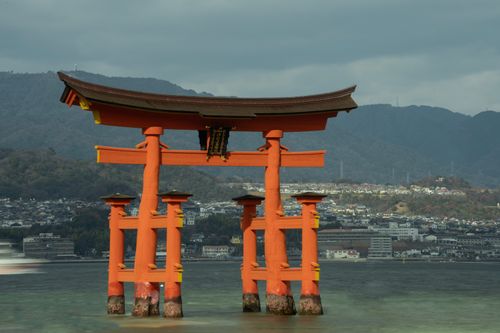 Free The floating torii gate of Itsukushima Shrine with mountains in the backdrop. Stock Photo