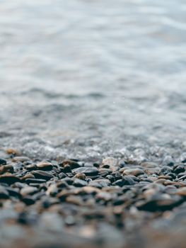 宁静海岸上，鹅卵石与温柔的波浪构成特写画面