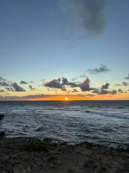 Free A breathtaking view of the ocean at sunset with vibrant skies and gentle waves. Stock Photo