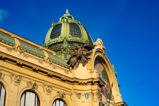Close-up of the stunning Art Nouveau architecture of Municipal House in Prague under a clear blue sky.