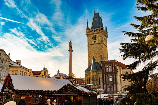 Vibrant Christmas market in Prague's Old Town Square with a view of the historic clock tower.