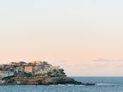 沿海房屋在日落时分俯瞰大海，天空宁静，营造出平和的景观