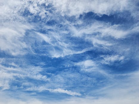 Beautiful natural scene of a blue sky filled with wispy white clouds, perfect for background or nature-themed projects.