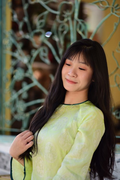 Free Smiling woman in light green traditional dress with decorative background. Stock Photo
