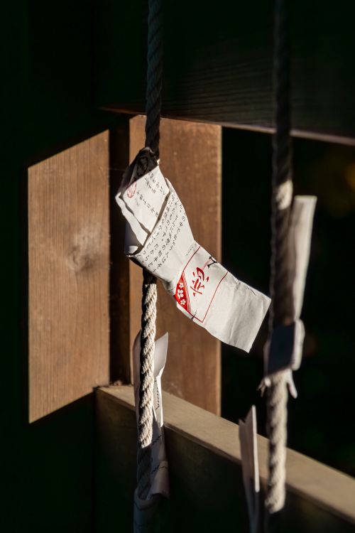 Free Paper fortune tied to a rope at a Shinto Shrine in Kawagoe, Japan, symbolizing traditional Japanese beliefs. Stock Photo