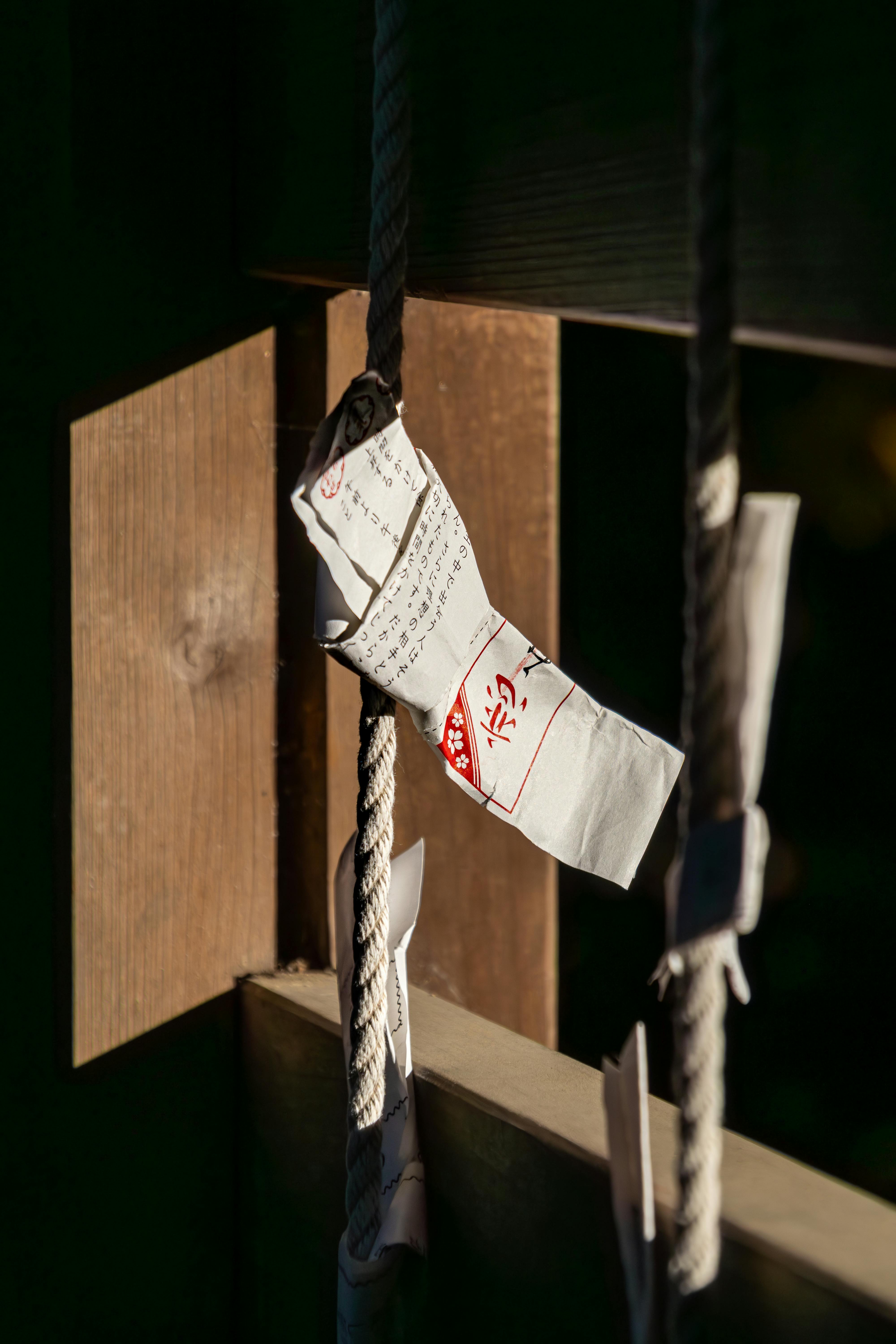 De franc Fortuna de paper lligada a una corda en un santuari sintoista de Kawagoe, Japó, que simbolitza les creences tradicionals japoneses. Foto d'estoc