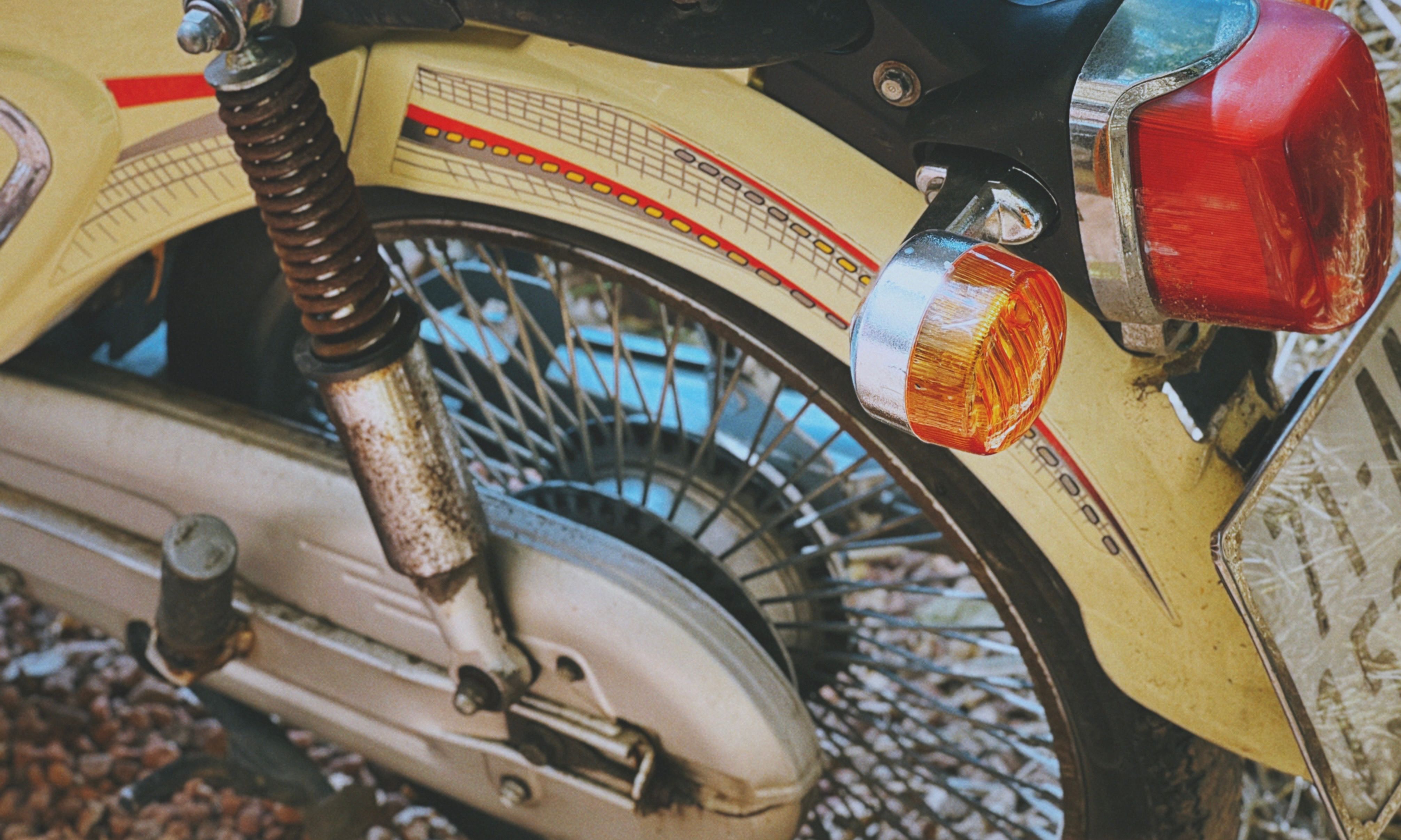 Detailed close-up of a vintage motorcycle's rear wheel and tail light.