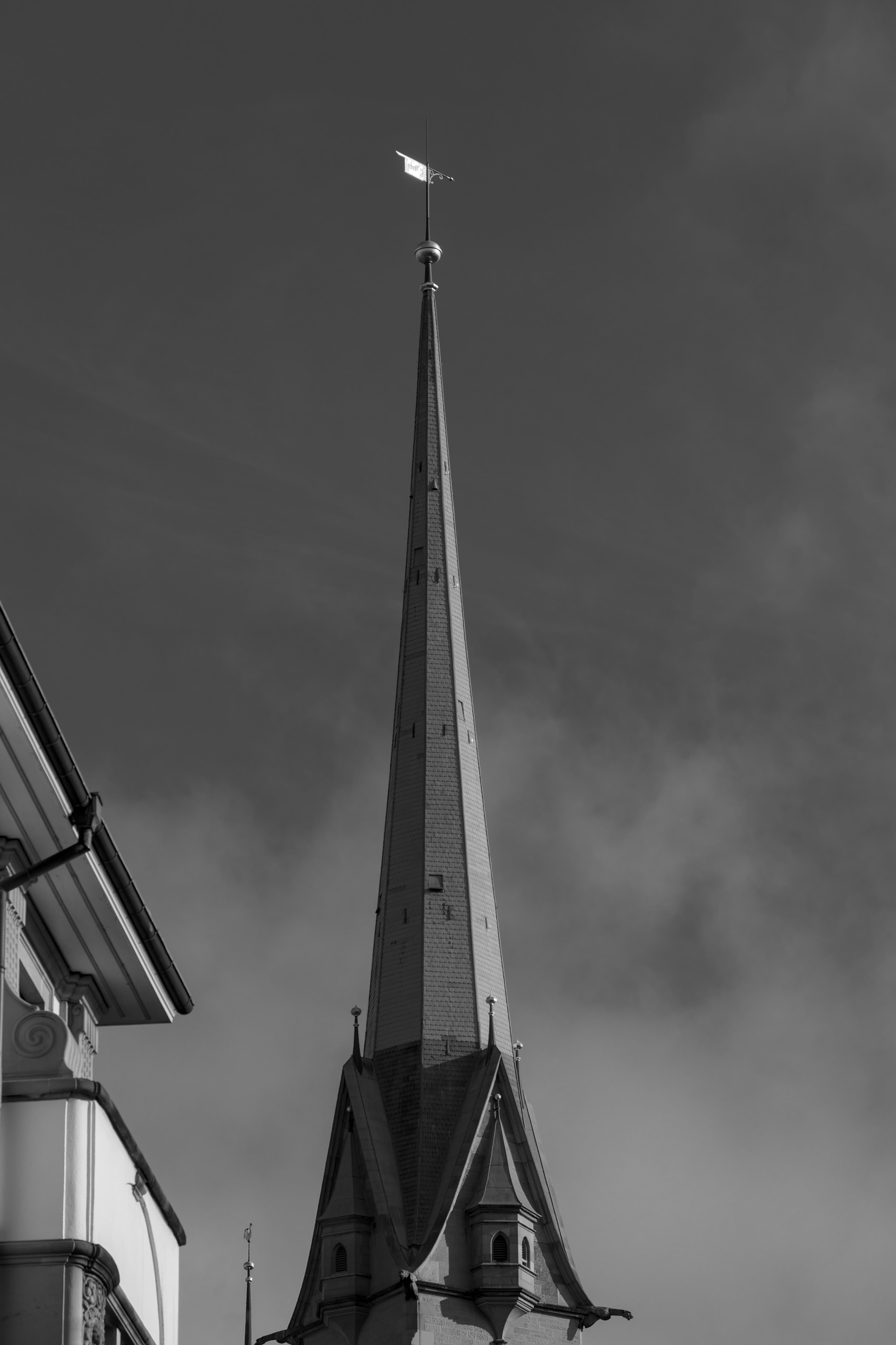 Gothic Church Spire Against Cloudy Sky in Zurich · Free Stock Photo
