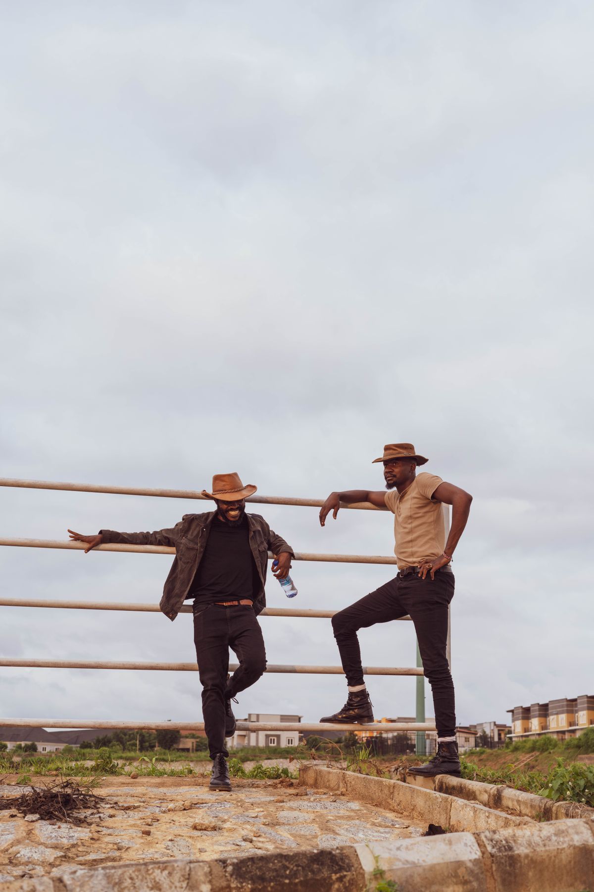 Two cowboys at a ranch fence