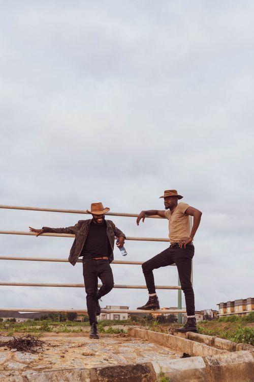 Free Two stylish African cowboys standing on a ranch in casual conversation. Stock Photo