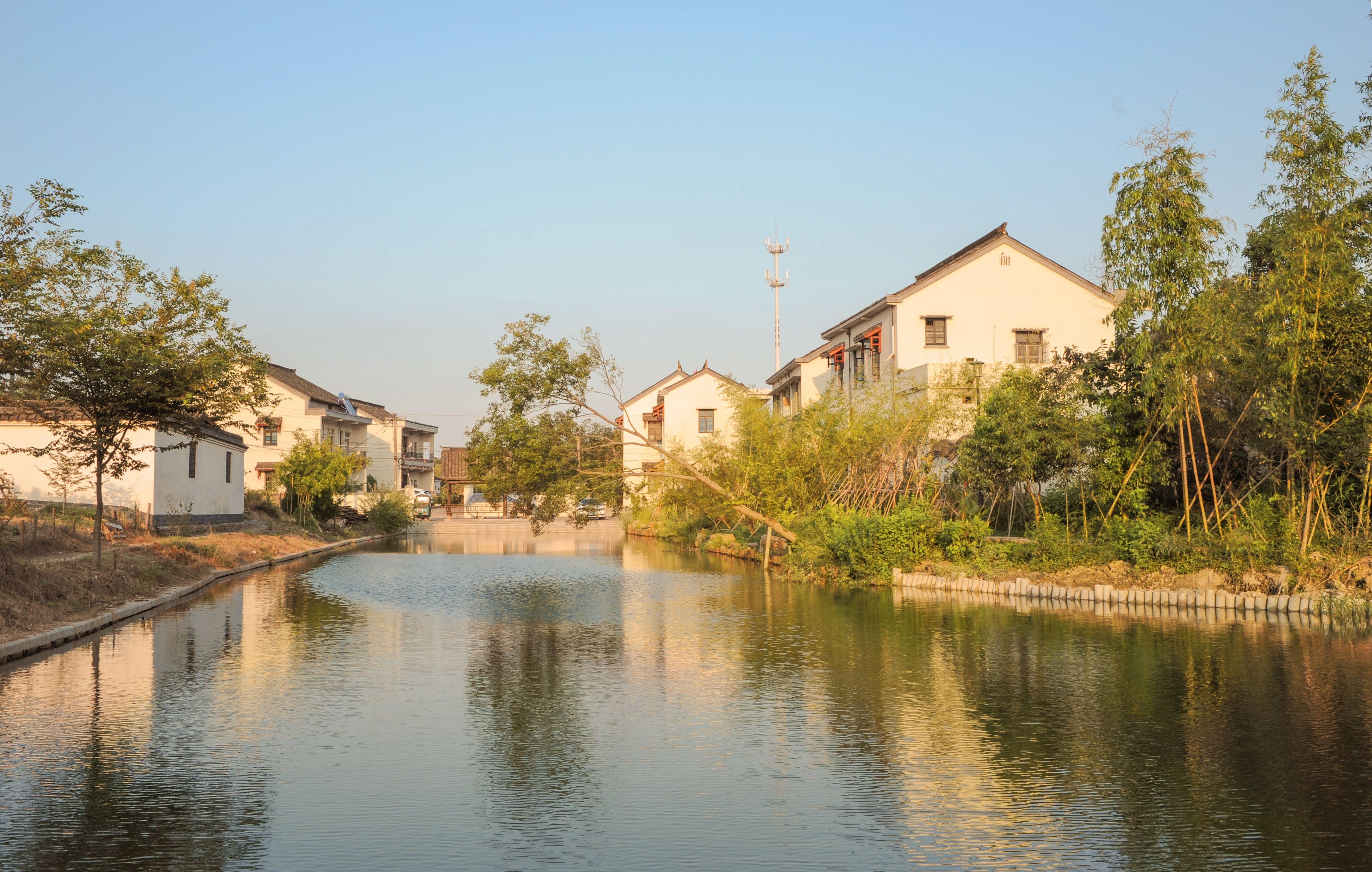Serene canal view with traditional architecture in Jiaxing, Zhejiang, China at sunset.