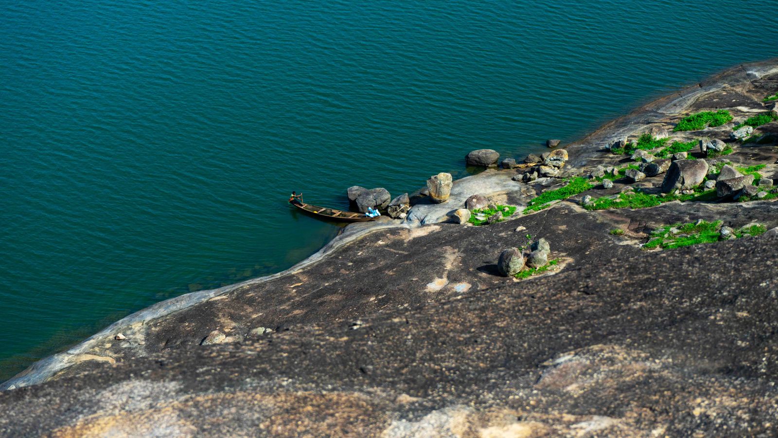 Scenic canoe by rocky lakeside shoreline, Togo