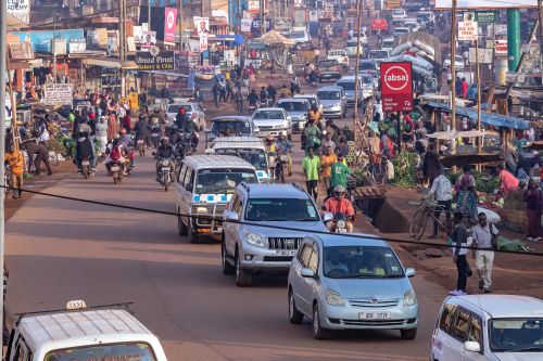 Free Vibrant street market in Uganda with numerous people and vehicles. Stock Photo