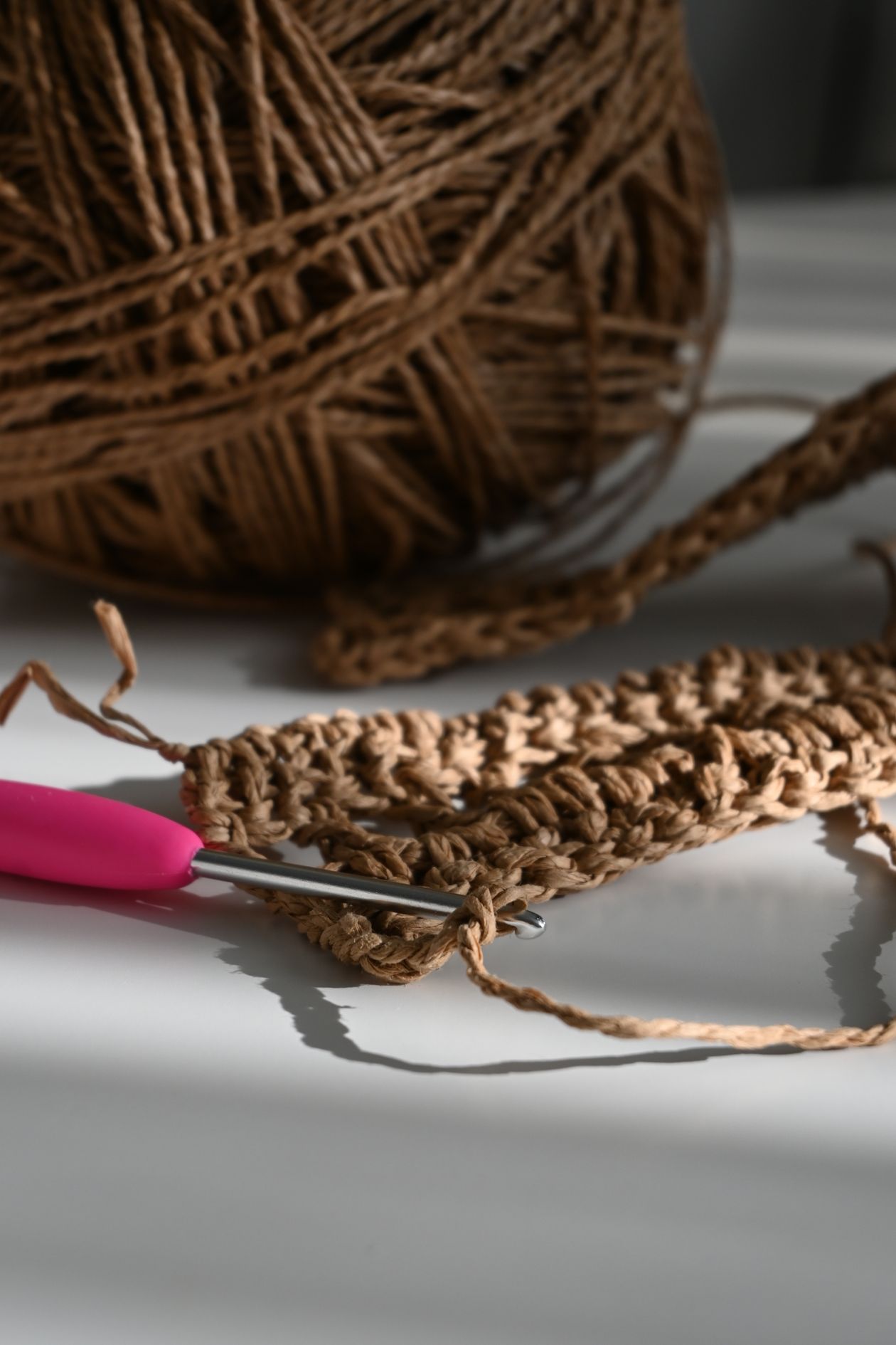 Agulha, fio e trabalho de crochê sobre mesa