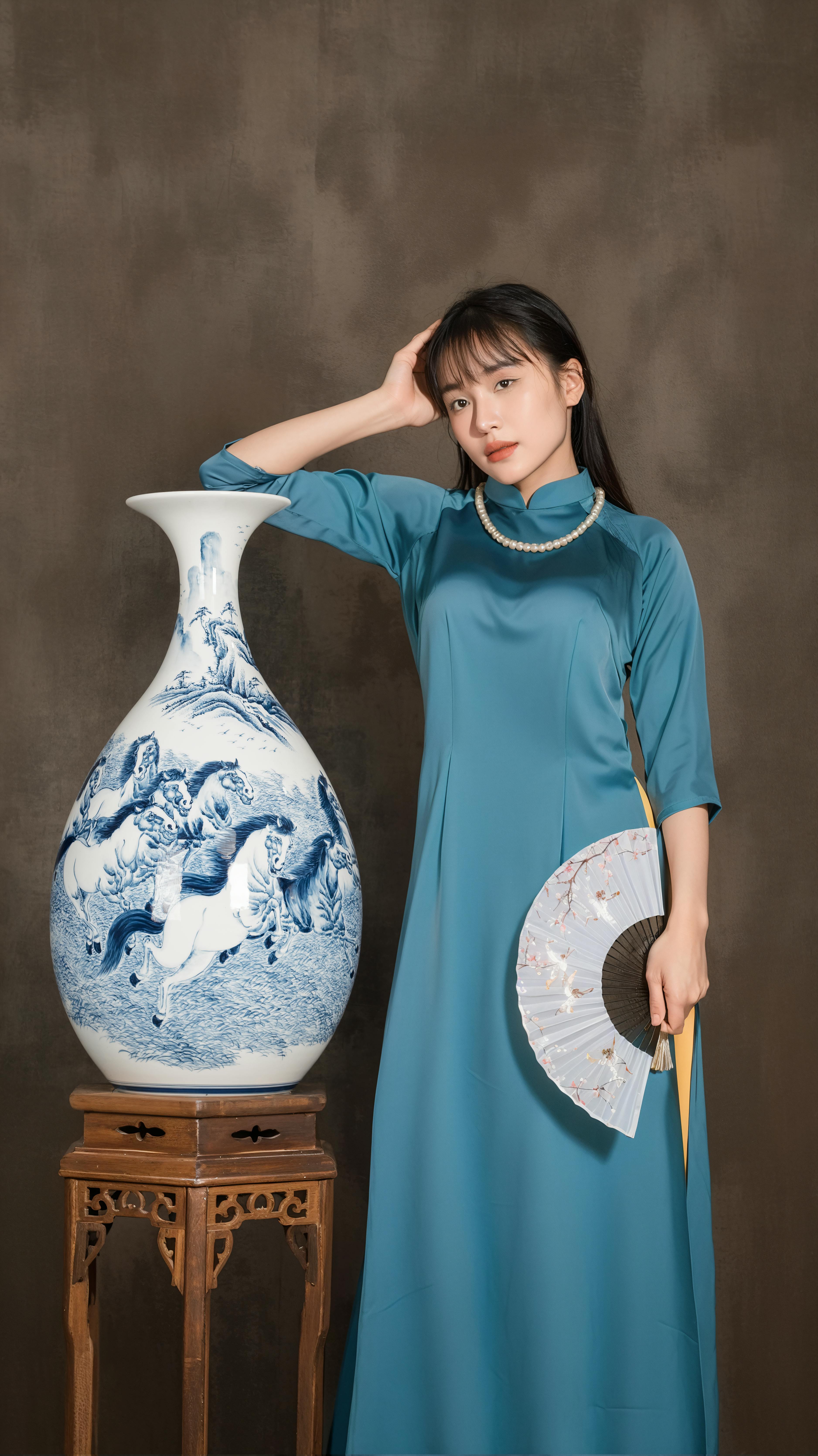 Elegant Vietnamese woman in ao dai posing with large ornate vase indoors.
