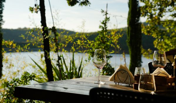 Peaceful outdoor dining setting overlooking a tranquil lake in Gramsh, Elbasan County, Albania.