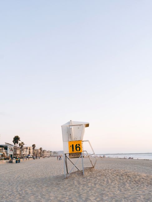Tranquil beach scene with a lifeguard tower in San Diego during sunset.