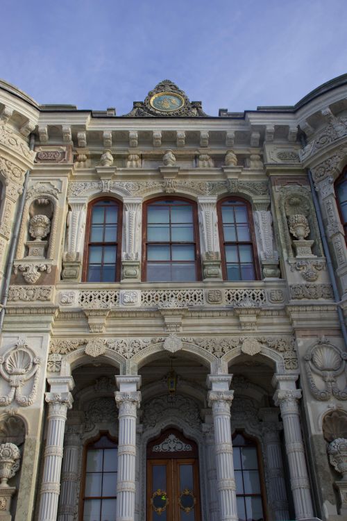 Free Close-up of an intricately decorated historical building facade with columns and detailed carvings. Stock Photo