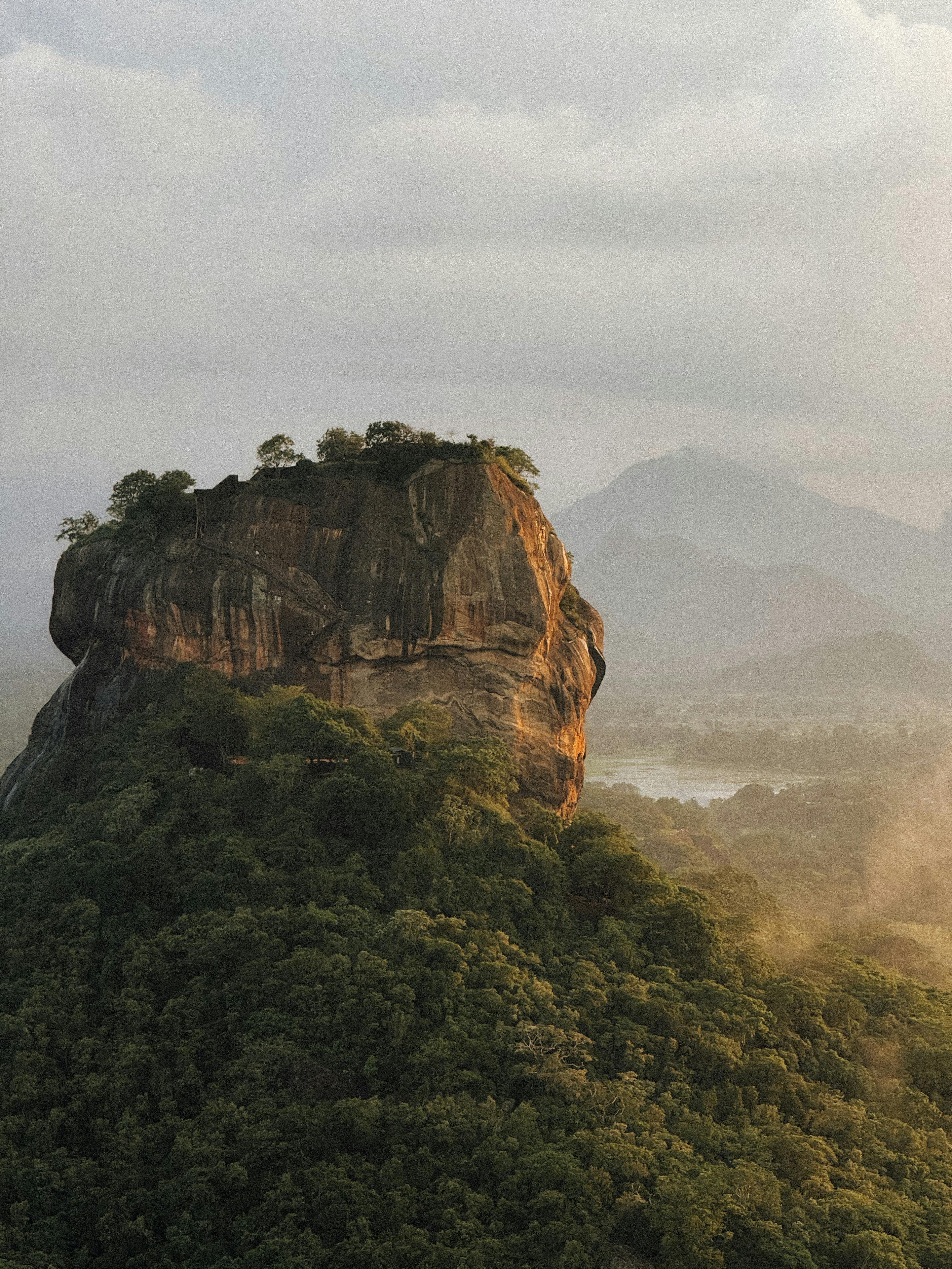 A breathtaking aerial view of Sigiriya Rock Fortress surrounded by lush greenery in Sri Lanka.