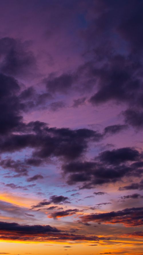 Free Dramatic purple and orange sunset sky with scattered clouds, capturing a stunning twilight scene. Stock Photo