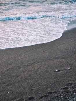 Tranquil ocean waves lapping a sandy shore at sunrise, creating a peaceful coastal scene.