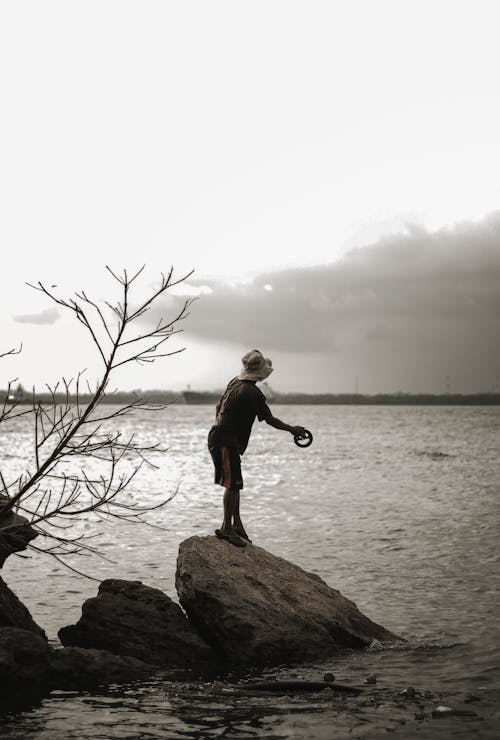 Man Standing on Rock Fishing