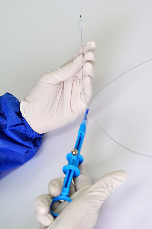 Free Close-up of a medical professional holding a catheter with precision in a sterile environment. Stock Photo