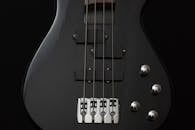 黑色电贝斯吉他的特写图像，重点展示了琴弦和琴身