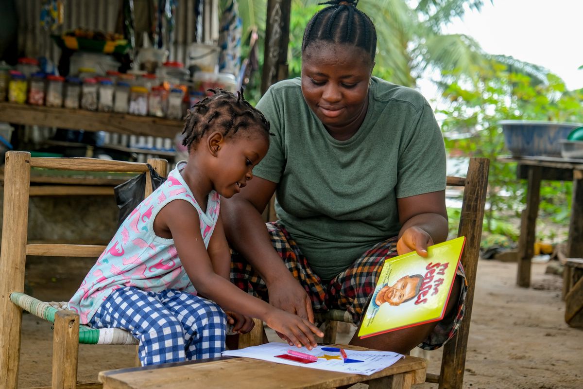A mother and young child reading together outdoors in Monrovia, Liberia