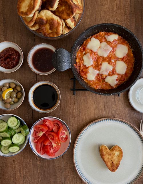 Free Delicious Turkish breakfast featuring menemen, olives, and fresh vegetables. Stock Photo