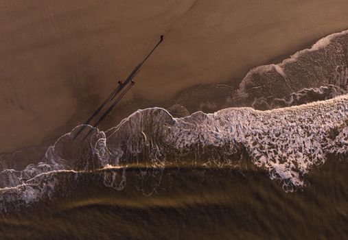 Stunning aerial view of the Henne Kirkeby beach, Denmark, showcasing waves and sandy shore.