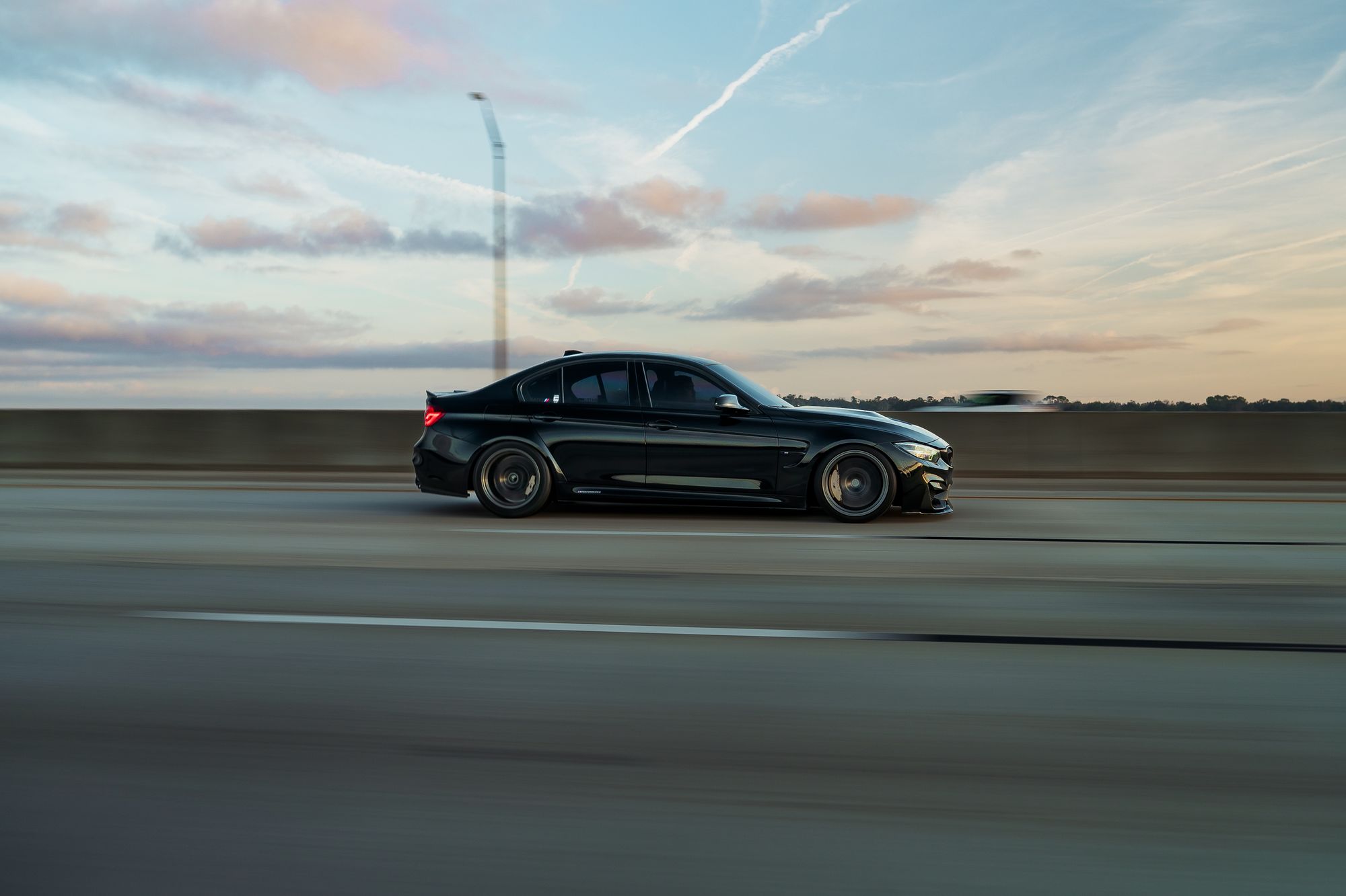 Luxury vehicle travelling along a highway at sunset