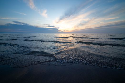 Beautiful sunset over serene ocean waves with vivid sky colors.