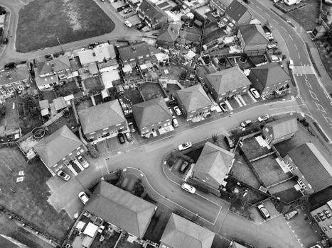 Aerial black and white view of a suburban neighborhood, showing houses and winding roads.
