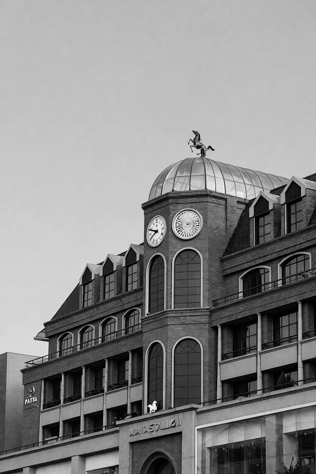 Ücretsiz Saat ve heykelin bulunduğu bir binanın siyah beyaz görüntüsü, kentsel bir sahne. Stok Fotoğraflar