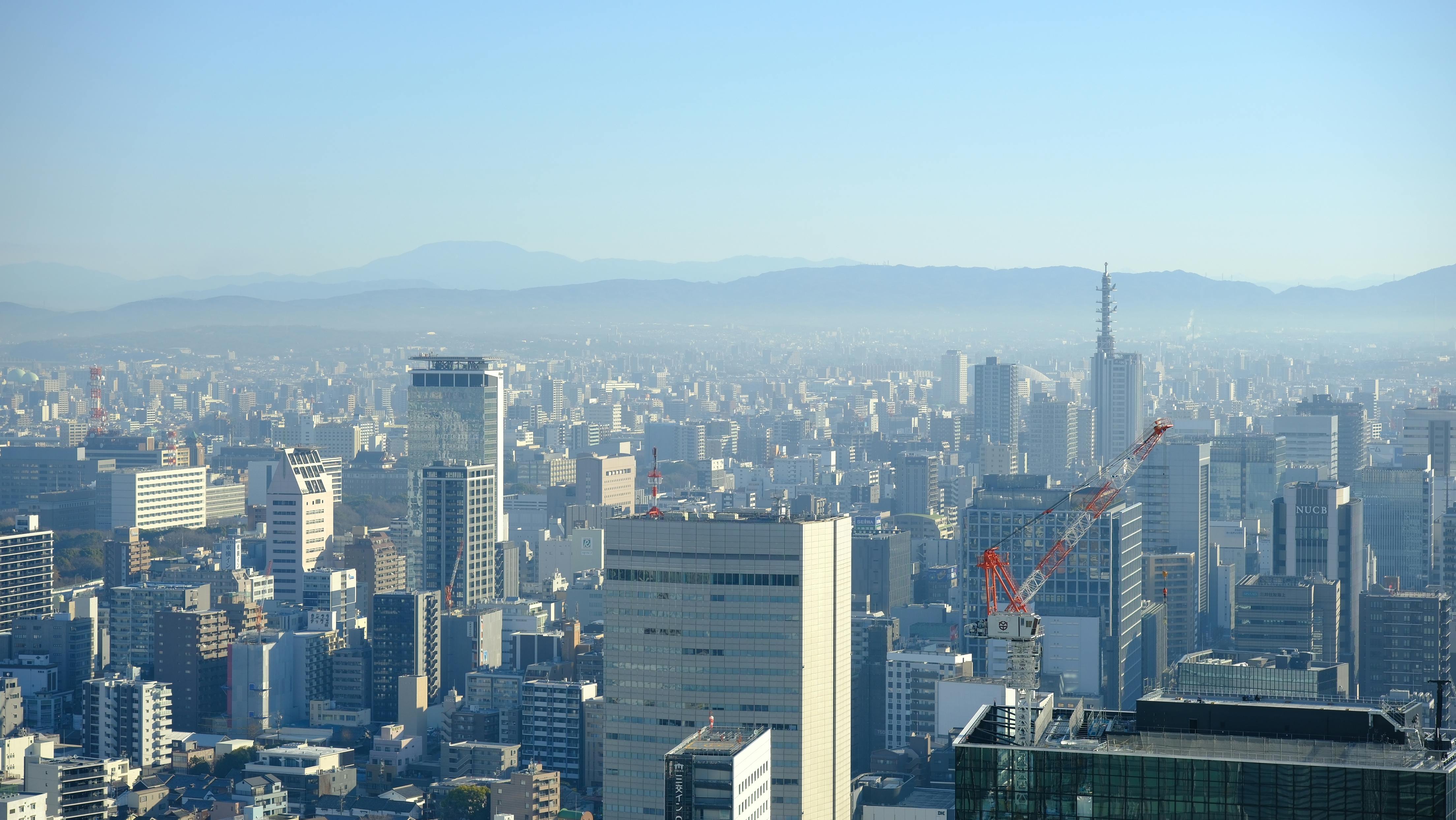無料 高層ビルと山々を背景にした大阪の街並みの息を呑むような眺め。 写真素材