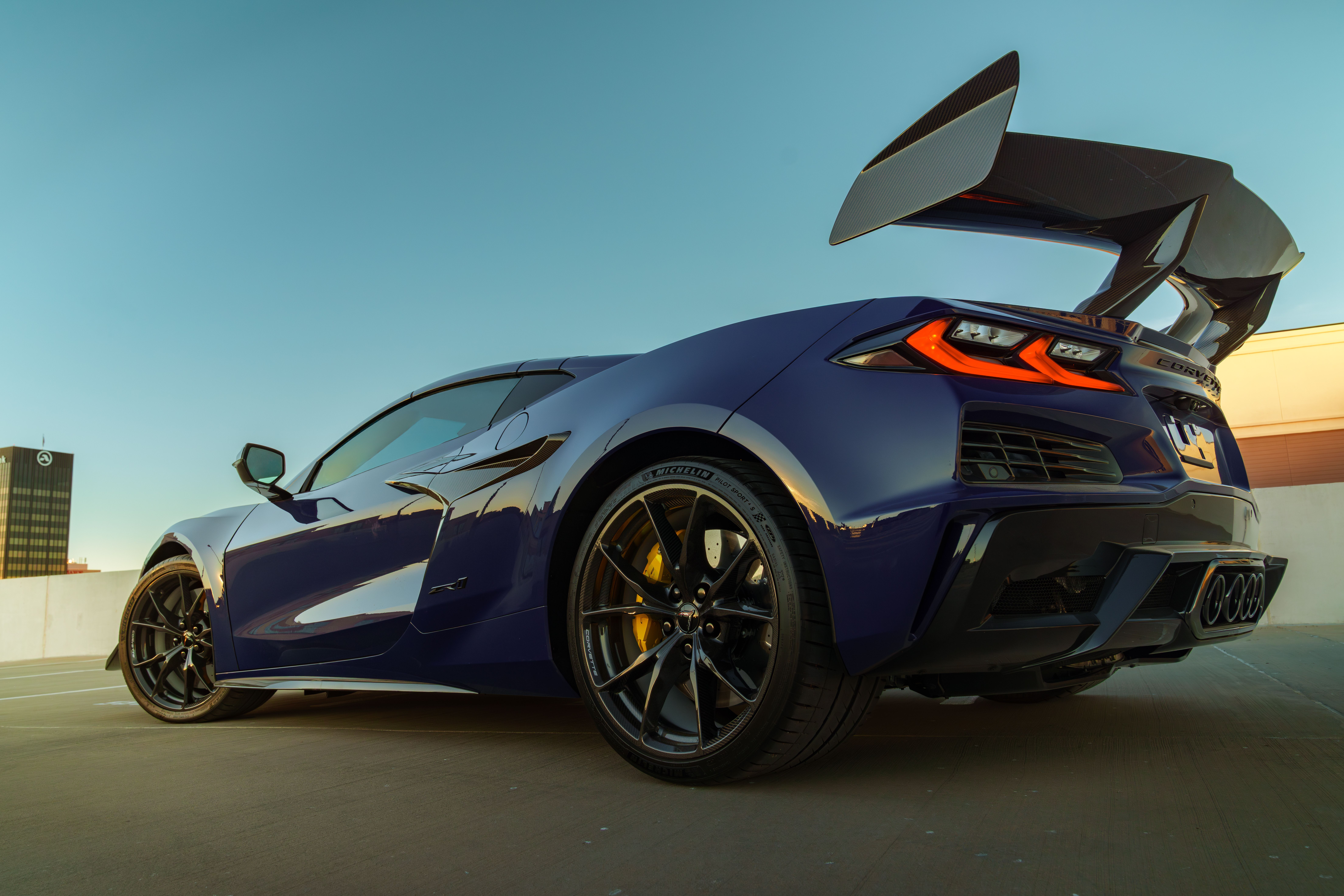 Low-angle view of a modern blue sports car on a city rooftop