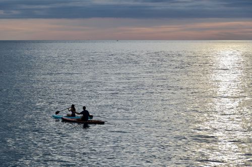 Free Two people kayaking at sunset in Manado, North Sulawesi, Indonesia. Stock Photo