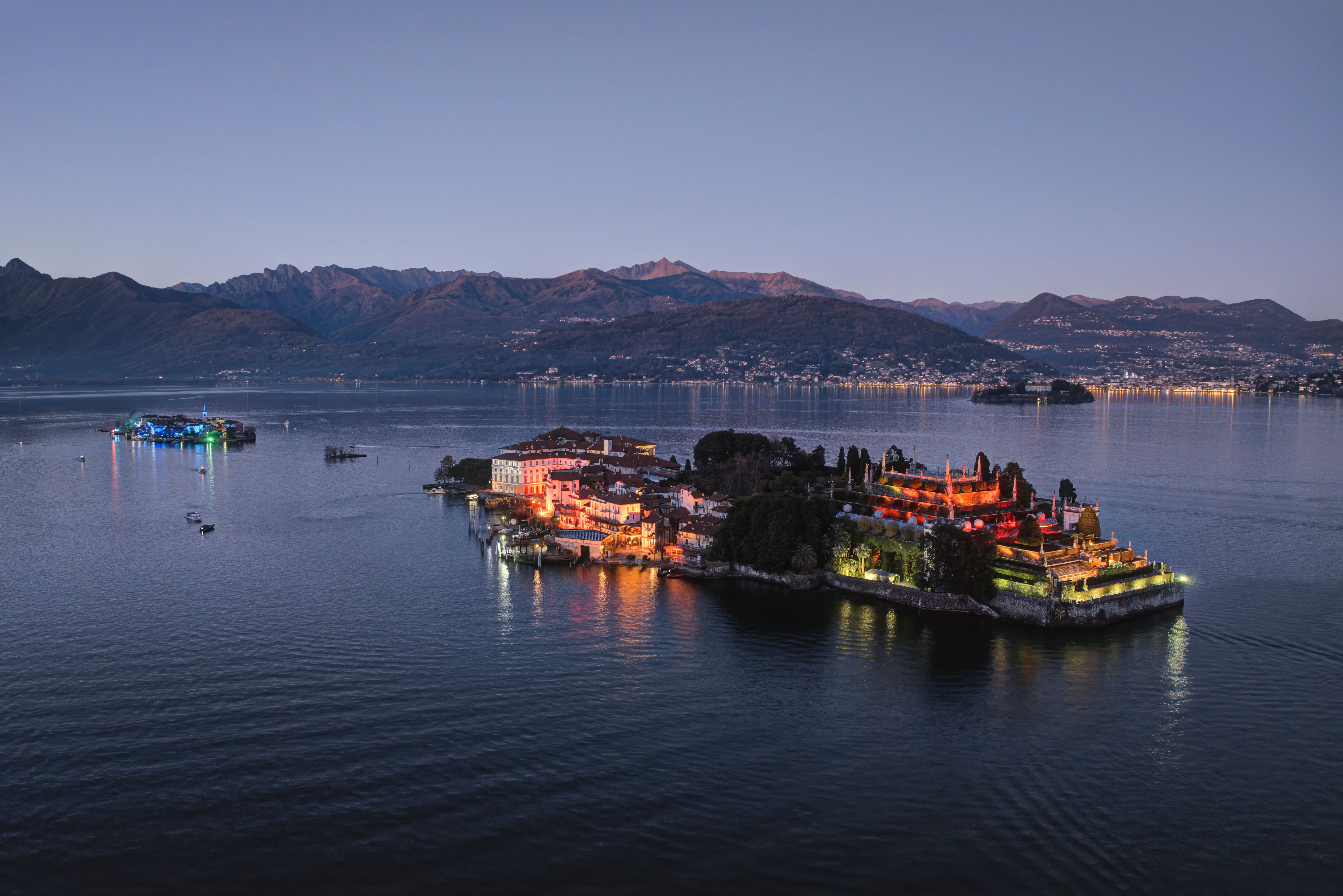 A breathtaking aerial shot of Lake Maggiore's islands illuminated at twilight, showcasing picturesque landscapes. A breathtaking aerial shot of Lake Maggiore's islands illuminated at twilight, showcasing picturesque landscapes.