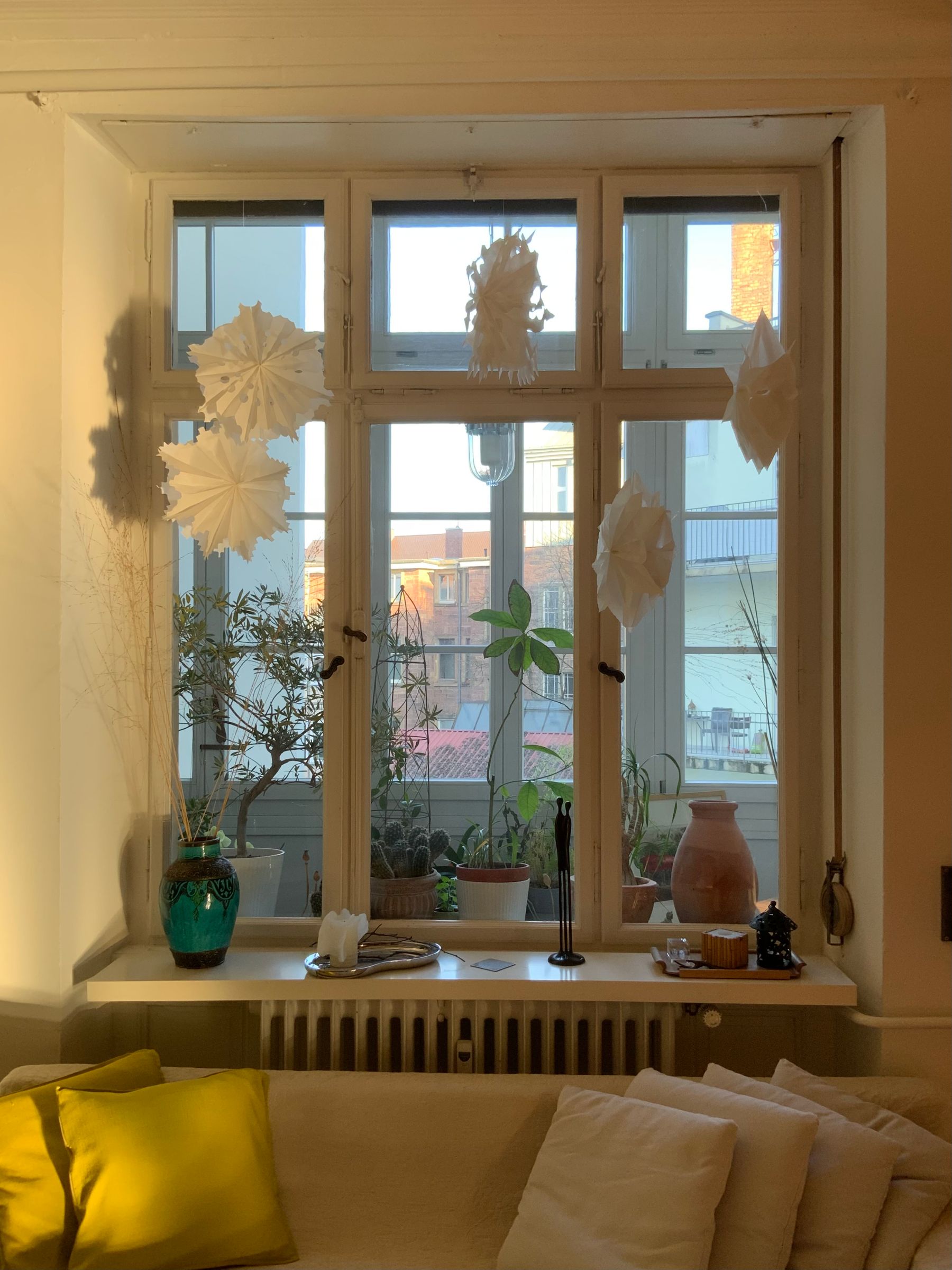 Calm sunlit living room after the holidays with plants and simple paper decorations