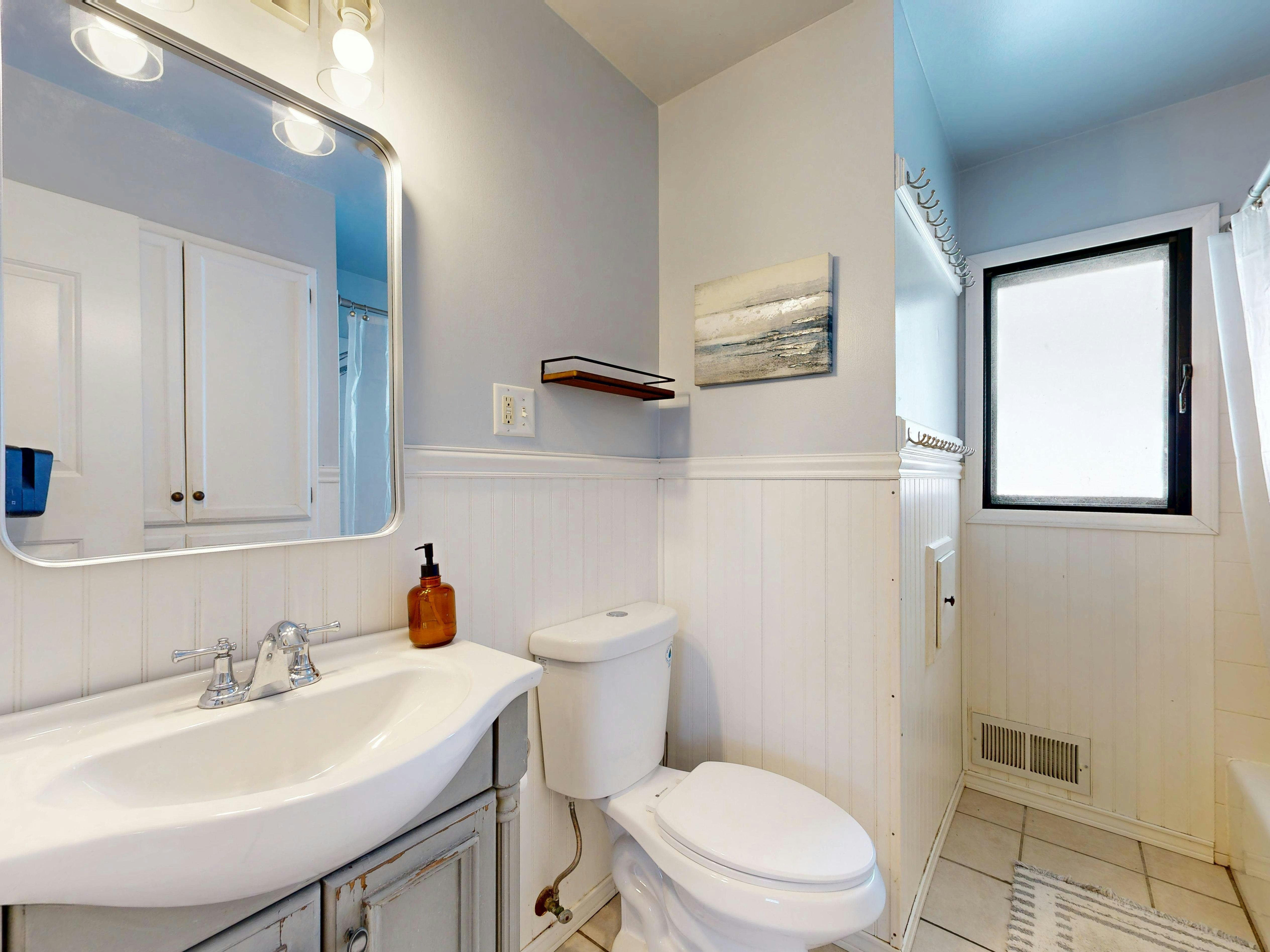 Karanlık bir banyoyu daha ferah ve aydınlık gösteren soft renkli duvar boyası ve modern banyo dekorasyonu.