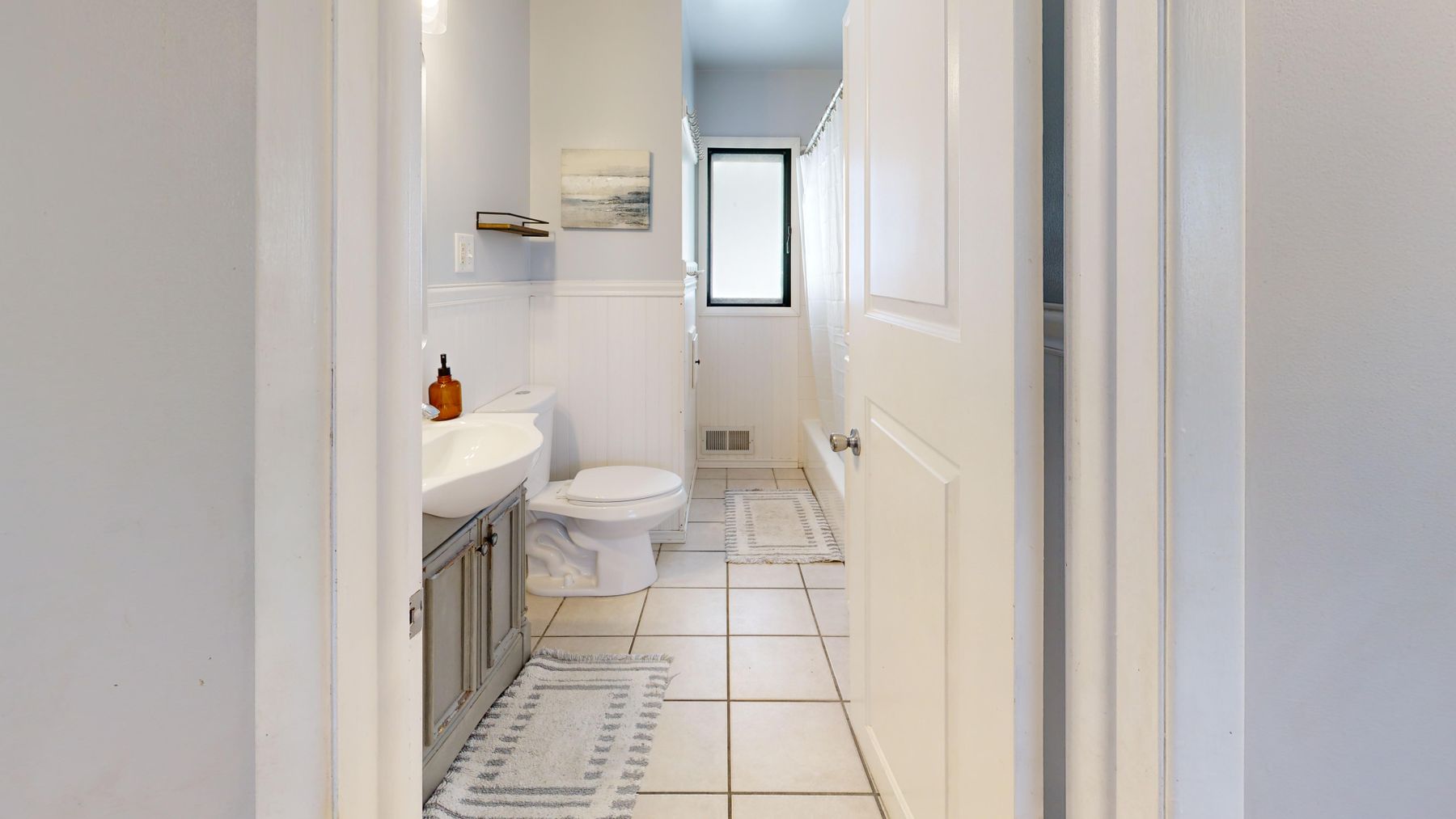 Scandinavian bathroom with pale ceiling, soft warm lighting and light wood