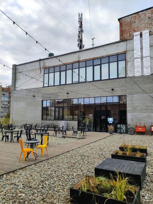 Free Outdoor cafe seating in an industrial-style setting with urban decor. Stock Photo
