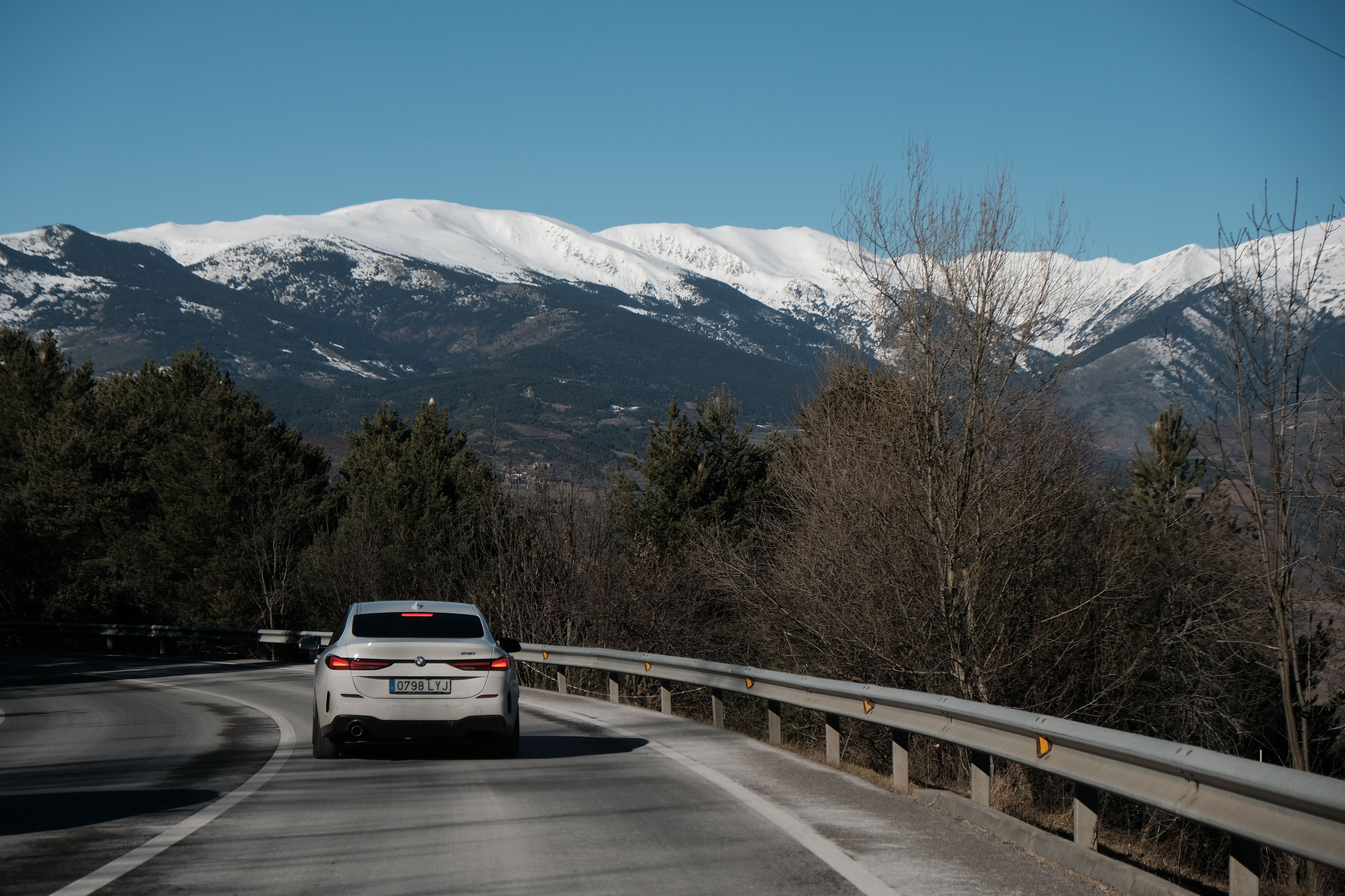 Car on Mountain Road with Scenic Snowy Peaks · Free Stock Photo