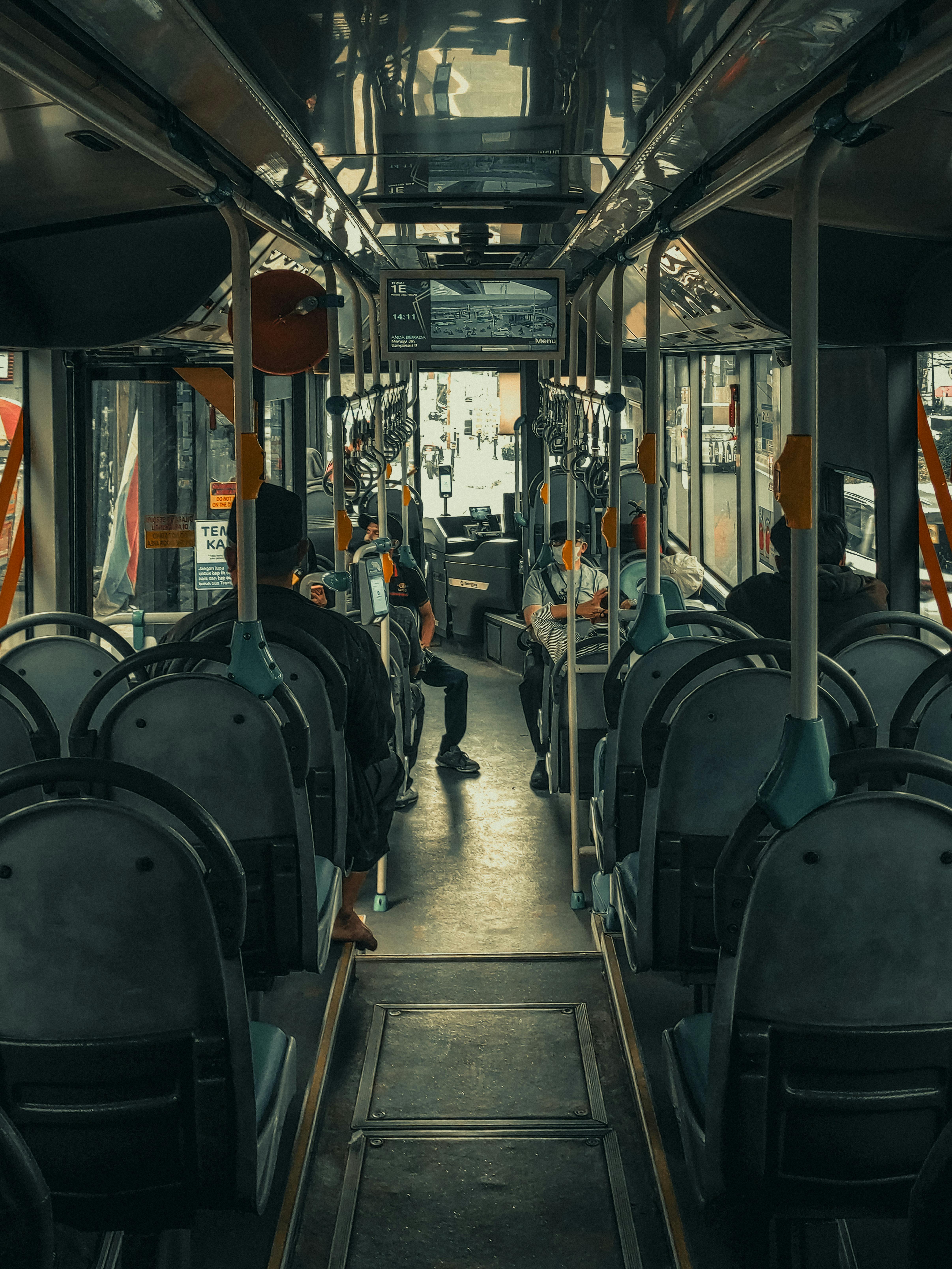 Moody interior shot of a city bus with passengers, highlighting urban commuting.