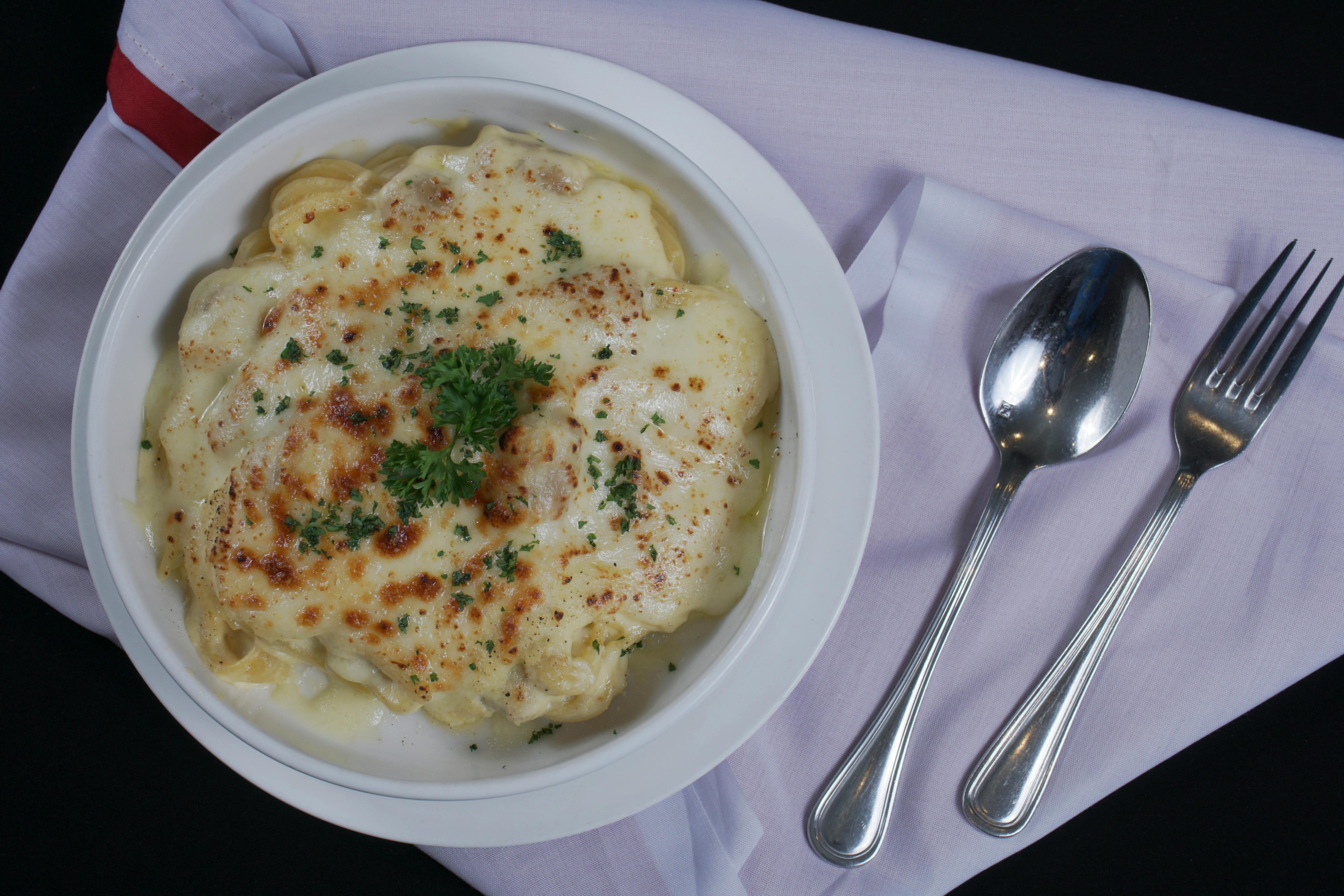 Casserole Dish With Layers Of Pasta, Cheese, And Vegetables In A Conventional Oven
