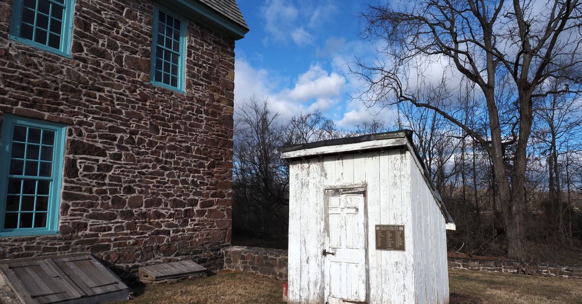 View of a historic stone building and weathered shed on a sunny day in Horsham, Pennsylvania.