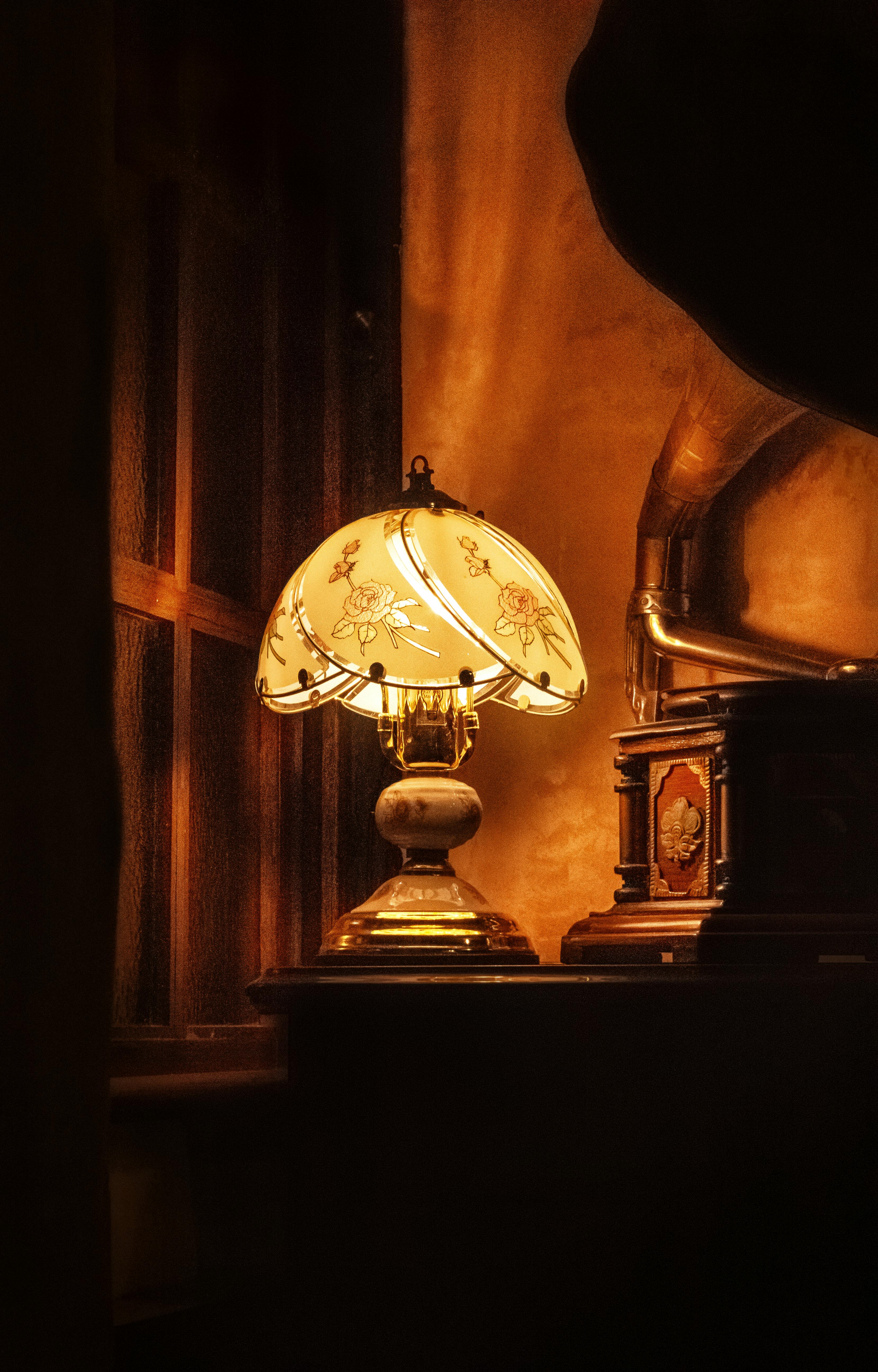 Gratis En varm innendørsscene med en elegant antikk lampe ved siden av en klassisk grammofon. Arkivbilde