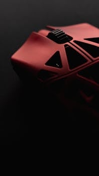 Close-up of a red ergonomic gaming mouse with futuristic design, set against a dark background.